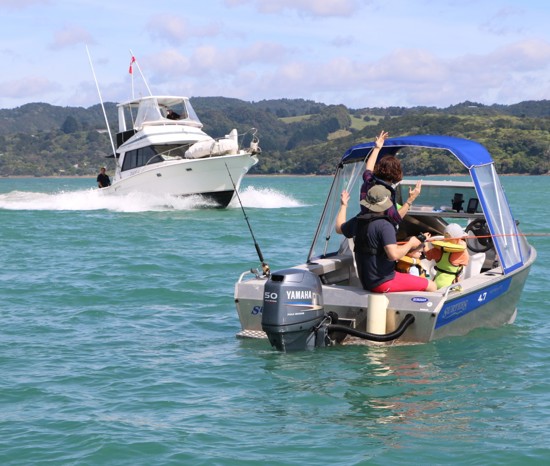 Large boat approaching smaller boat.