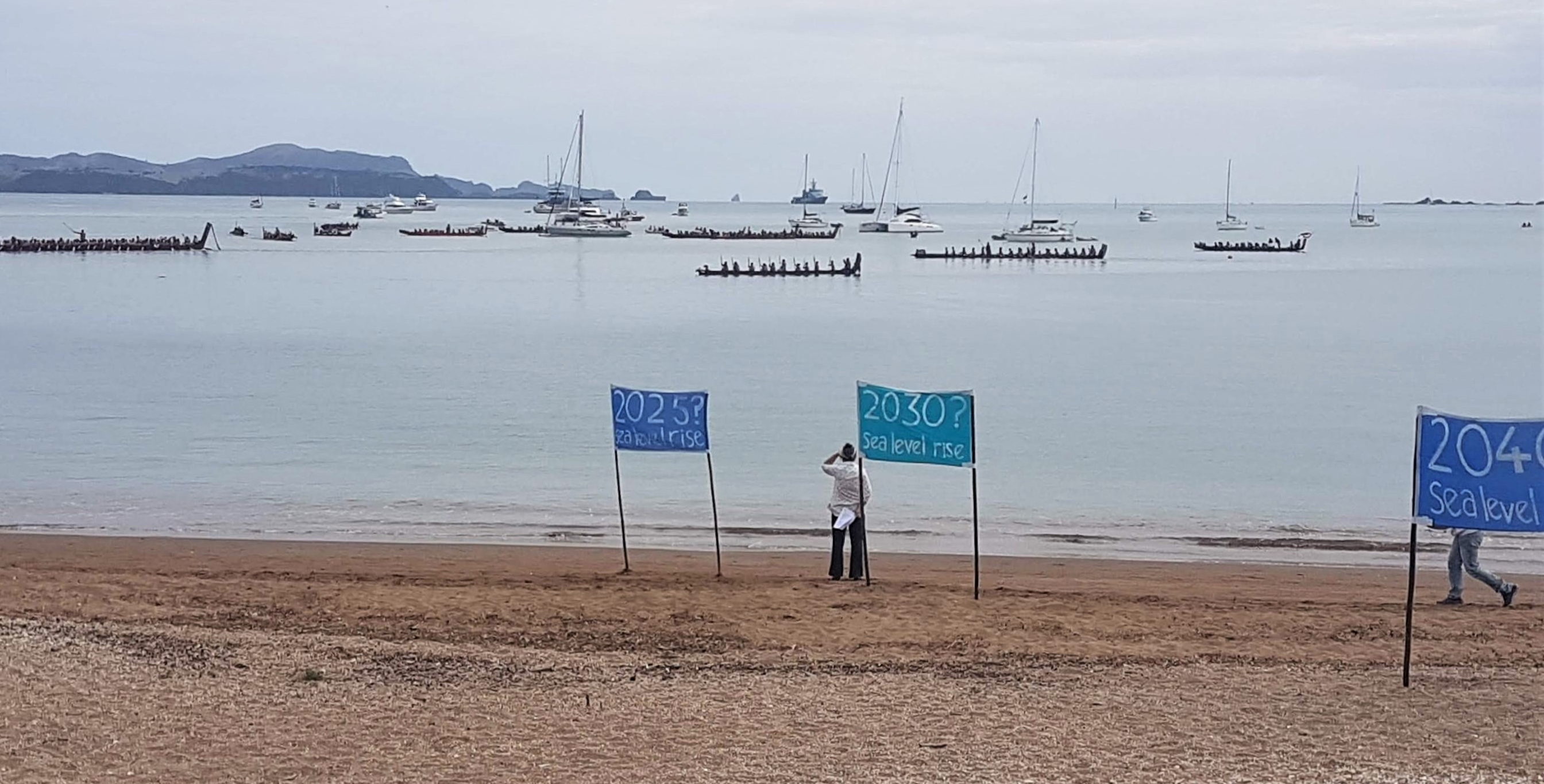 Banners placed by members of the public on the beach at Waitangi suggest possible sea level rise scenarios.