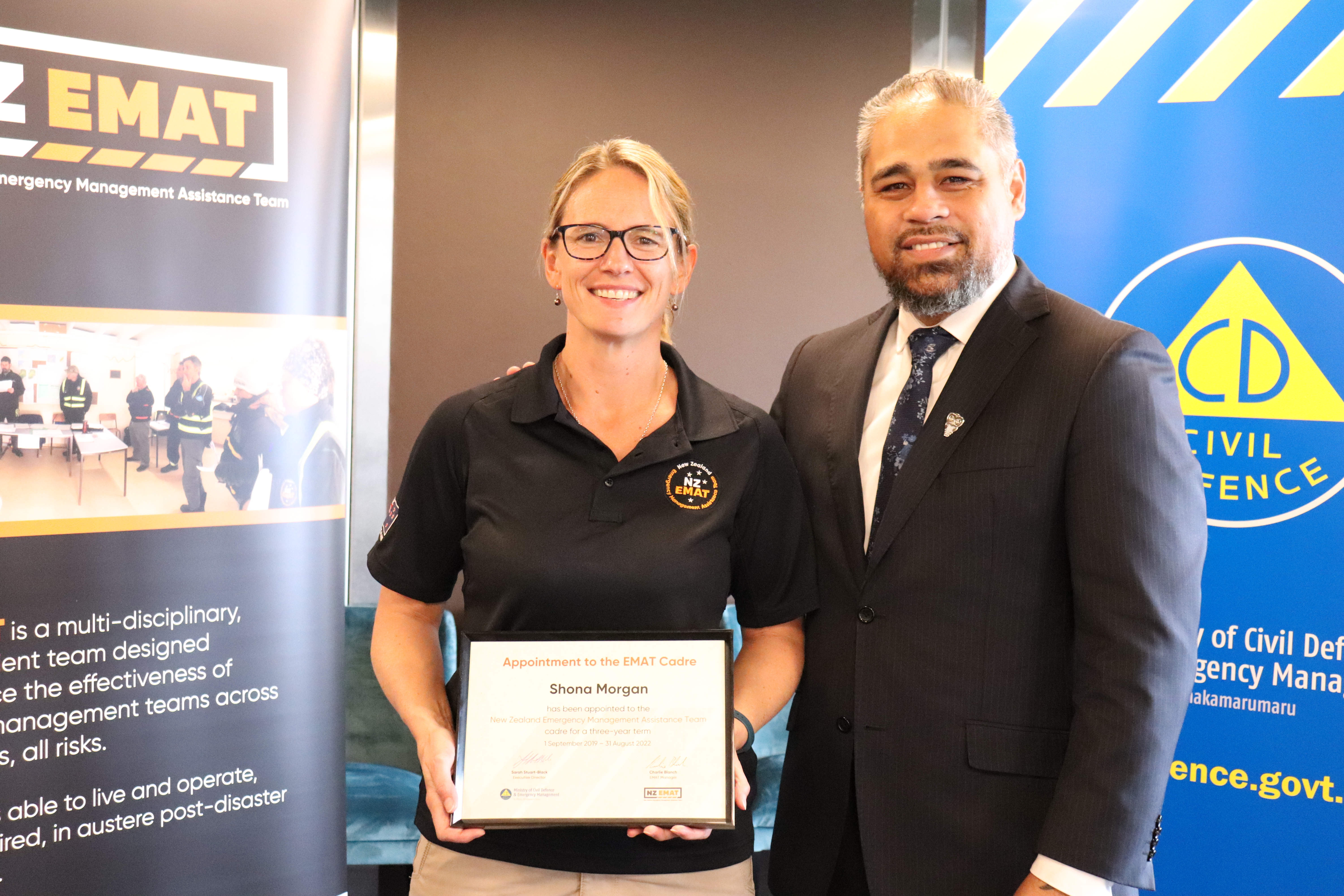 Shona Morgan standing next to Civil Defence Minister Peeni Henare holding her certificate of appointment.