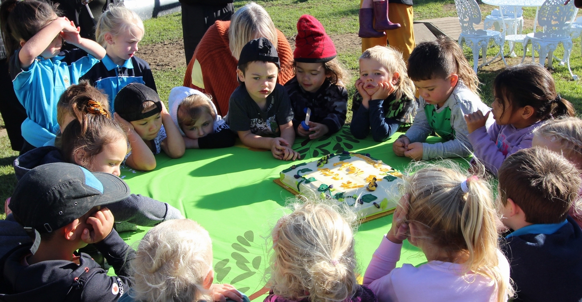 Children looking a celebration cake.
