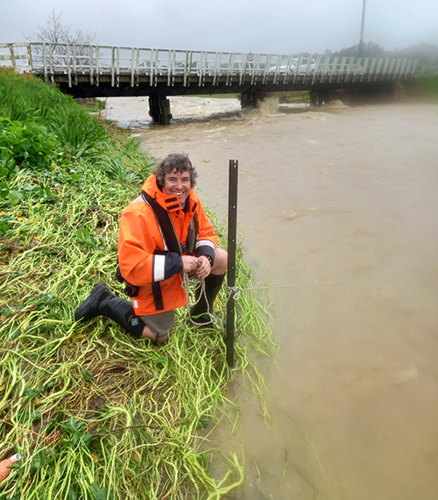 Man by river in flood.