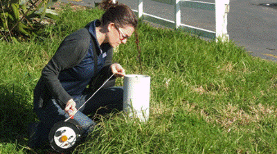A Northland Regional Council Monitoring Officer measuring the groundwater level at Russell. 